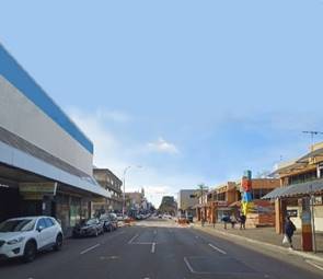 A street with cars and buildings

Description automatically generated