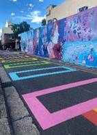 A street with colorful painted walls

Description automatically generated