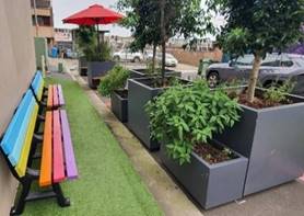 A colorful bench next to a wall

Description automatically generated