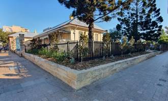 A house with a fence and trees

Description automatically generated