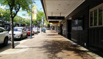A sidewalk with cars parked on the side

Description automatically generated
