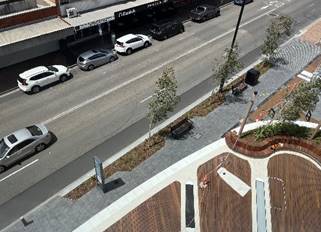 Aerial view of a street with cars and a skate park

Description automatically generated