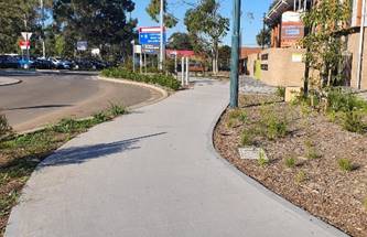 A sidewalk with a sign on it

Description automatically generated with medium confidence