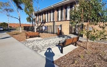 A building with a bench and a tree

Description automatically generated